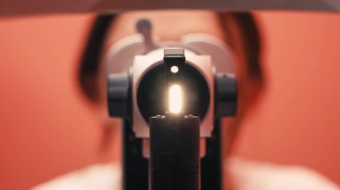 Ekipmanla göz muayenesi yapılan kişi