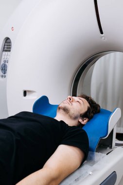 Adam tıbbi görüntüleme makinesinin içinde yatıyor.
