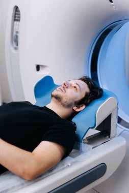 Tıbbi görüntüleme makinesinde yatan adam.