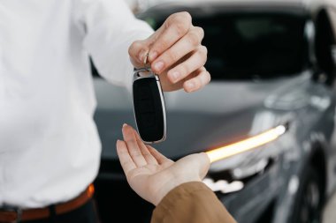 Adam arabanın anahtarlarını başka birine veriyor.