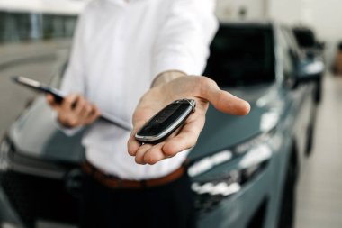 Adam arabanın anahtarını başka birine veriyor.