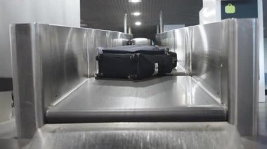 Taşıma bandında siyah bavul