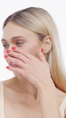Kırmızı tırnaklı bir kadın yüzüne dokunuyor