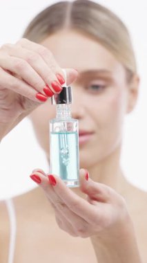 Kadın elinde şişe serumu tutuyor.