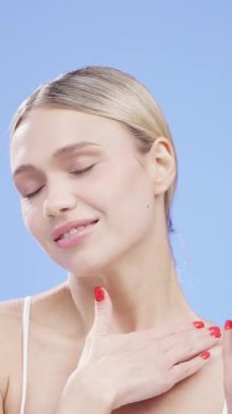 Gülümseyen ve boynuna dokunan bir kadın