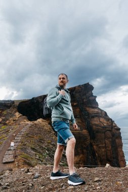 Kahverengi kayalıkların yanında duran adam