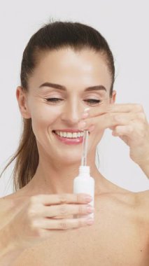 Kadın damlatıcıyla serum uyguluyor