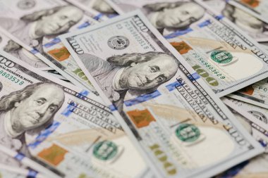 Yüz dolarlık banknotlar karmaşık detaylar ve canlı renkler sergiliyor, dokuları ve desenleri vurguluyor, büyüleyici bir düzende zenginliği ve finansal başarıyı temsil ediyor.