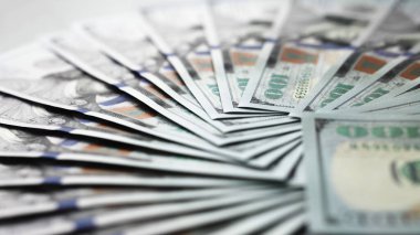 Düzenlenmiş yüz dolarlık banknotların yakın plan görüntüsü, para biriminin eşsiz dokusu ve renklerini vurgulamak, mali başarıyı ve ekonomik temaları temsil etmek