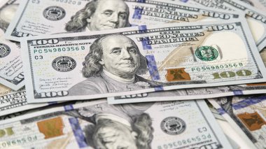 Sayısız yüz dolarlık banknotlara yakından bakmak, detaylı tasarım ve dokuların altını çizmek, çağdaş toplumda zenginliğin ve finansal işlemlerin görsel bir temsilini yaratmak,