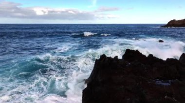 Dalgalar kayalık kıyı şeridine çarpıyor