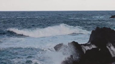 Dalgalar kayalık kıyı şeridine çarpıyor