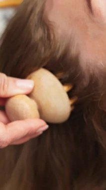 Uzun saç üzerinde taş alet kullanan kişi