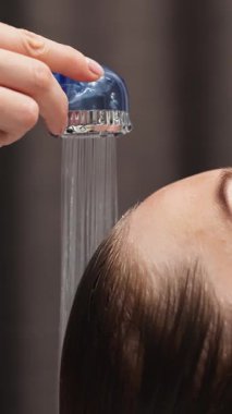 Duş başlığından saçlara akan su