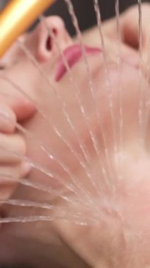 Kadın su damlacıklarıyla yüz bakımı uyguluyor.