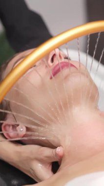 Kadın su spreyiyle yüz bakımı görüyor.