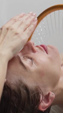 Kadın su akıntısının altında dinleniyor.