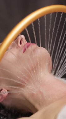 Kadın su jetleri ile yüz bakımı görüyor.