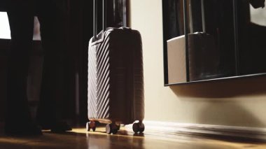 Bavul duvarın yanında duruyor.