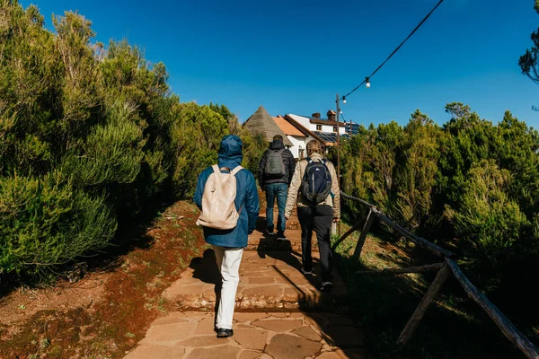 Gezginler canlı yeşillikler arasından taştan bir yola yükselirler, kırsal bir yapıya yaklaşırlar, açık hava macerasının özünü yakalar ve keşiflerin neşesini yakalarlar.