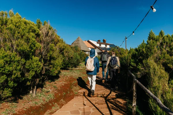 Gezginler, canlı yeşilliklerle kaplanmış, rahat bir kulübeye yaklaşan, doğanın güzelliğinin ve keşfin heyecanının tadını çıkaran, pitoresk bir patikada gezinirler.