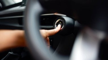 Modern araçta el ile çalıştırma düğmesi, parlak iç tasarım ve ileri teknoloji, çağdaş otomotiv yeniliğinin özünü yakalıyor.