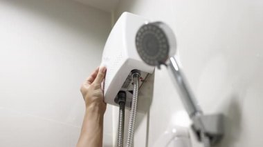 Banyoda duş başlığını ayarlayan kişi..