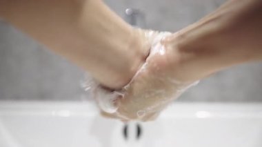 Lavaboda sabunla yıkanan iki el..