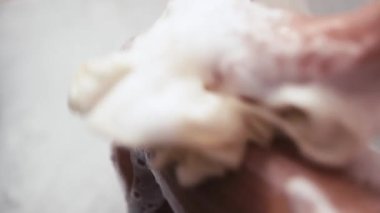 Saç yıkarken şampuan süren kişi.