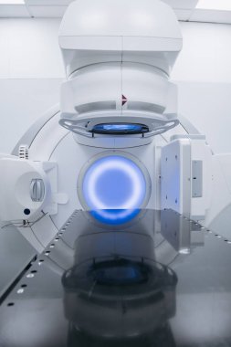 Onkoloji tedavisi için dizayn edilen doğrusal hızlandırıcı, aydınlatılmış özellikler ve çağdaş bir tıbbi ortamda yer alan cilalı bir yüzey, sağlık hizmetlerindeki yenilikleri vurguluyor