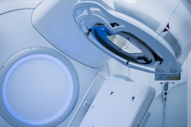 Onkoloji tedavisi için gelişmiş doğrusal hızlandırıcı, modern tasarım ve teknolojiyi parlak bir tıbbi ortamda sergiliyor, hassasiyet ve özeni vurguluyor