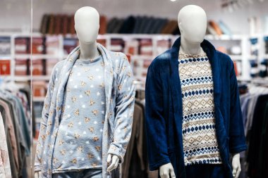 Mankenler, yumuşak dokular ve çağdaş tasarımlar, rahatlık ve moda cazibesinin vurgulandığı, perakende satış ortamında şık bir giyim sergilemektedirler.