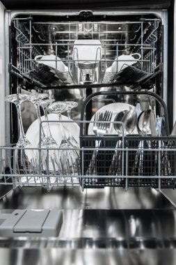 Temiz tabakları, bardakları ve çatal bıçakları güzelce yerleştiren bir bulaşık makinesinin içeriden görünüşü, cihazın işlevselliğini ve modern tasarım özelliklerini vurguluyor.