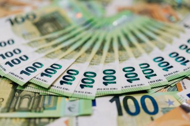 100 avroluk banknotların dairesel düzenlenmesi, ayrıntılı tasarımlar ve canlı renkler sergilenmesi, mali bolluk ve ekonomik büyümeyi temsil ediyor