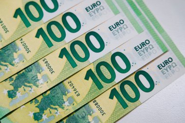 Ayrıntılı tasarımlar, renkler ve güvenlik özellikleri, finans ve ekonomiyi sembolize eden 100 avroluk banknotlar yakın planda sergileniyor