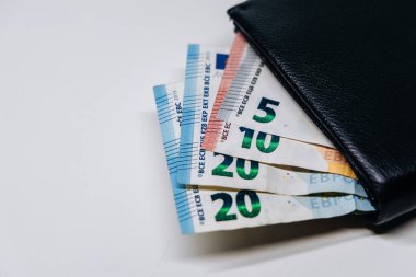 Siyah bir cüzdanda gösterilen çeşitli banknotlar, para yönetimi, mali planlama ve nakit para rolünün önemini vurgulayan günlük işlemler