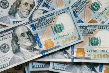 Ayrıntılı tasarım, renk ve güvenlik unsurlarını vurgulayarak, para birimi ve ekonomik değeri sembolize ederek, üst üste yığılmış çeşitli yüz dolarlık banknotların yakın plan çekimi