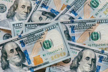 Yüzlerce dolarlık banknotların yakın plan görüntüsü, para biriminin detaylı tasarım ve dokularını vurgulamak, mali bolluğu ve ekonomik temaları temsil etmek,