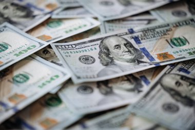 Yüzlerce dolarlık banknotlar, karmaşık tasarım ve dokuların altını çizerek zenginlik ve finansal bolluk ortamı yaratıyor.