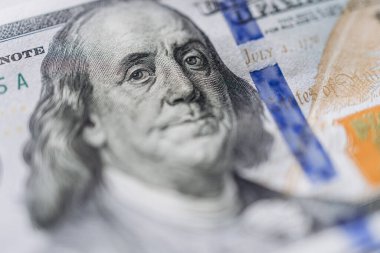 Çağdaş ekonomide para birimi ve finansal işlemleri temsil eden karmaşık tasarımları ve canlı renkleri vurgulayan bir banknotun ayrıntılı yakın çekimleri