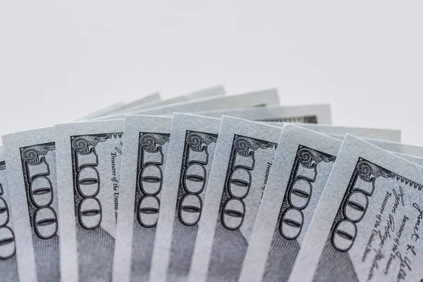 Yüzlerce dolarlık banknotların yakın plan görüntüsü, karmaşık tasarım ve dokuların altını çizmek, temiz bir ortamda refah ve finansal bolluğu sembolize etmek.