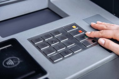 ATM tuş takımı ile el etkileşimi, düğmeleri ve kullanıcı deneyimini vurgulamak, modern bankacılık teknolojisi ve finansal işlemlerde erişilebilirliği göstermek
