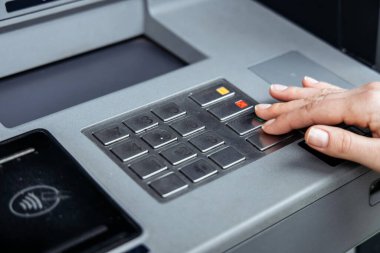 ATM düğmeleri ile el etkileşimi, para çekme sürecini vurgulamak, kullanıcı deneyimi ve modern bankacılık teknolojisini güvenli bir ortamda vurgulamak