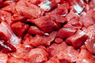 Çiğ et parçaları bir kasapta, zengin kırmızı renkler ve çeşitli dokular sergilenerek, pişirme ve yemek hazırlama kalitesi ve tazeliği vurgulanıyor.