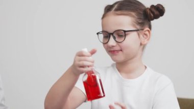 Genç kız kırmızı sıvıyı şişeye karıştırıyor..