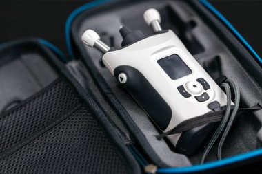 Ekranı olan taşınabilir elektronik cihaz ve koruyucu bir çantada depolanan kontroller, ek aksesuarlar için bir ağ cebi içeriyor