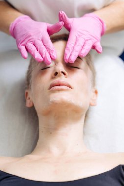 Kadın güzellik uzmanıyla yüz maskesi takıyor.