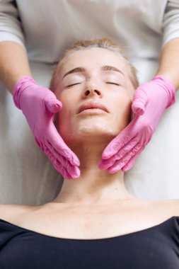 Güzeller güzeli genç bir kadın güzellik salonunda yüz masajı yaptırıyor. güzellik, sağlık.