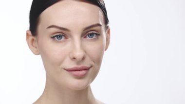 Güzel bir kadın parlayan cilt için yüz nemlendirici sürüyor estetik cilt rutini, profesyonel güzellik tedavisi..