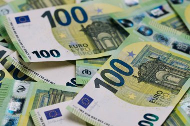 Çeşitli 100 Euro 'luk banknotların yakın plan çekimleri, para biriminin ayrıntılı tasarımları ve güvenlik özelliklerini vurguluyor